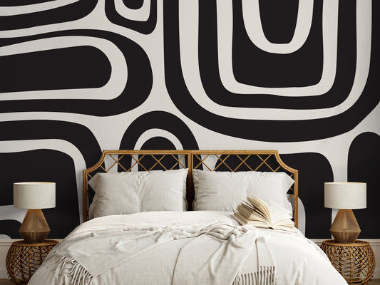 a bed with a black and white wall behind it