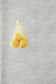a yellow fruit hanging from a hook on a wall