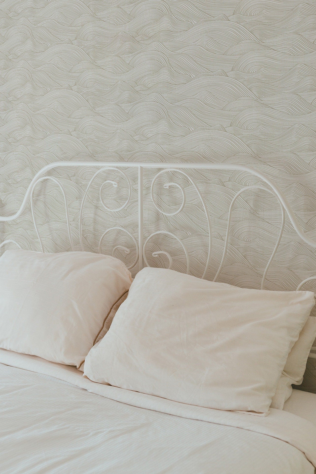 a bed with two pillows and a white headboard