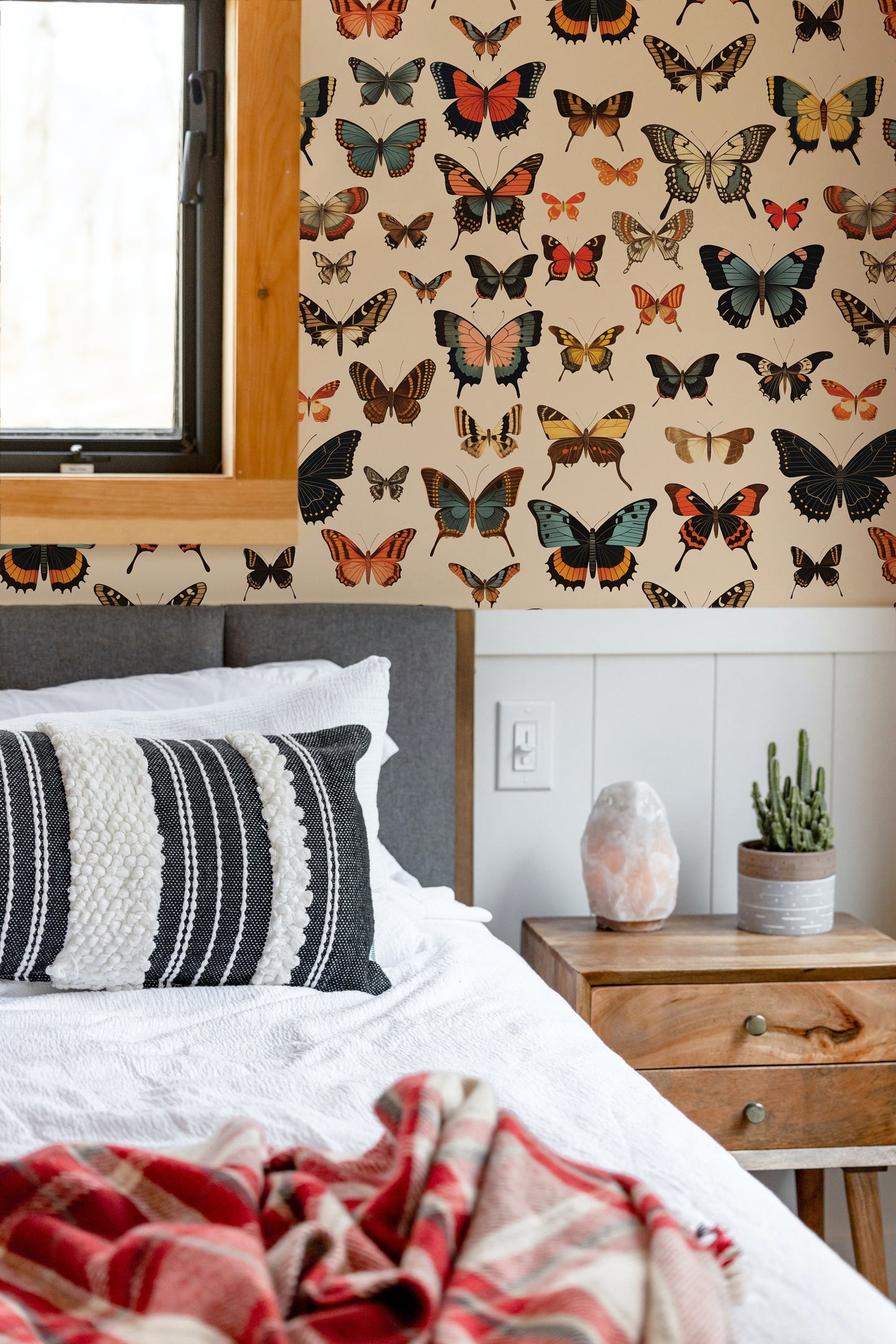 a bedroom with a bed and a window with butterflies on it